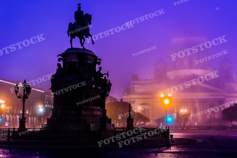 Эта атмосферная фотография захватывает туманный вечер на Исаакиевской площади в Санкт-Петербурге, где силуэт памятника Николаю I вырисовывается на фоне мягко освещённого Исаакиевского собора. Таинственный туман, сочетающийся с неоновым свечением городских огней, создаёт загадочное и впечатляющее зрелище. Это изображение идеально подойдёт для иллюстрации статей о городских легендах, может быть использовано в тематических выставках или как элемент дизайна интерьеров, стремящихся передать дух Санкт-Петербурга.